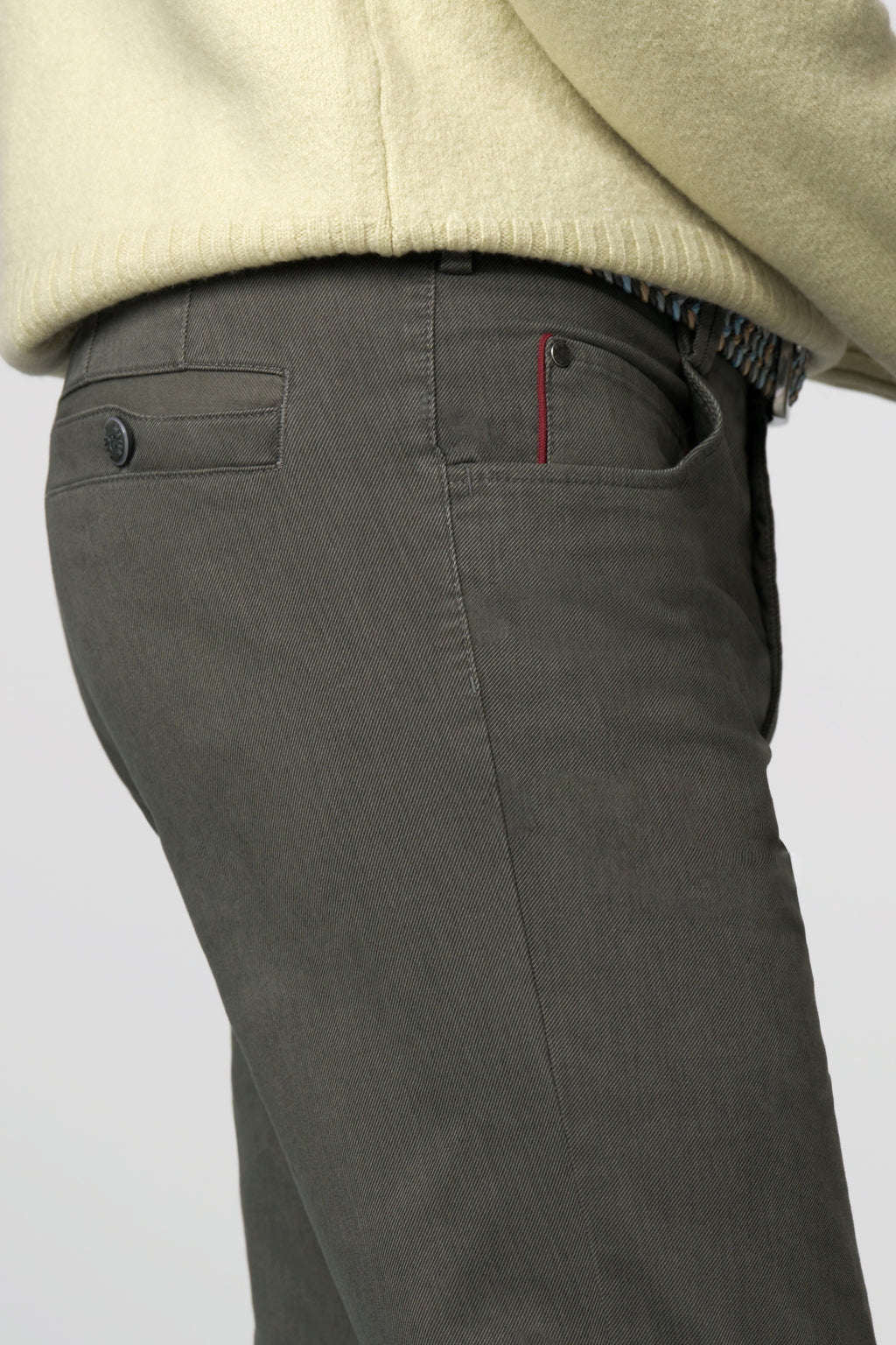 Dark gray pants with a beige sweater on a light gray background